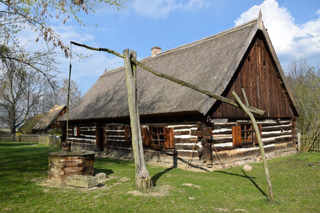 Skansen w Wolsztynie zabytkowa drewniana chata i studnia